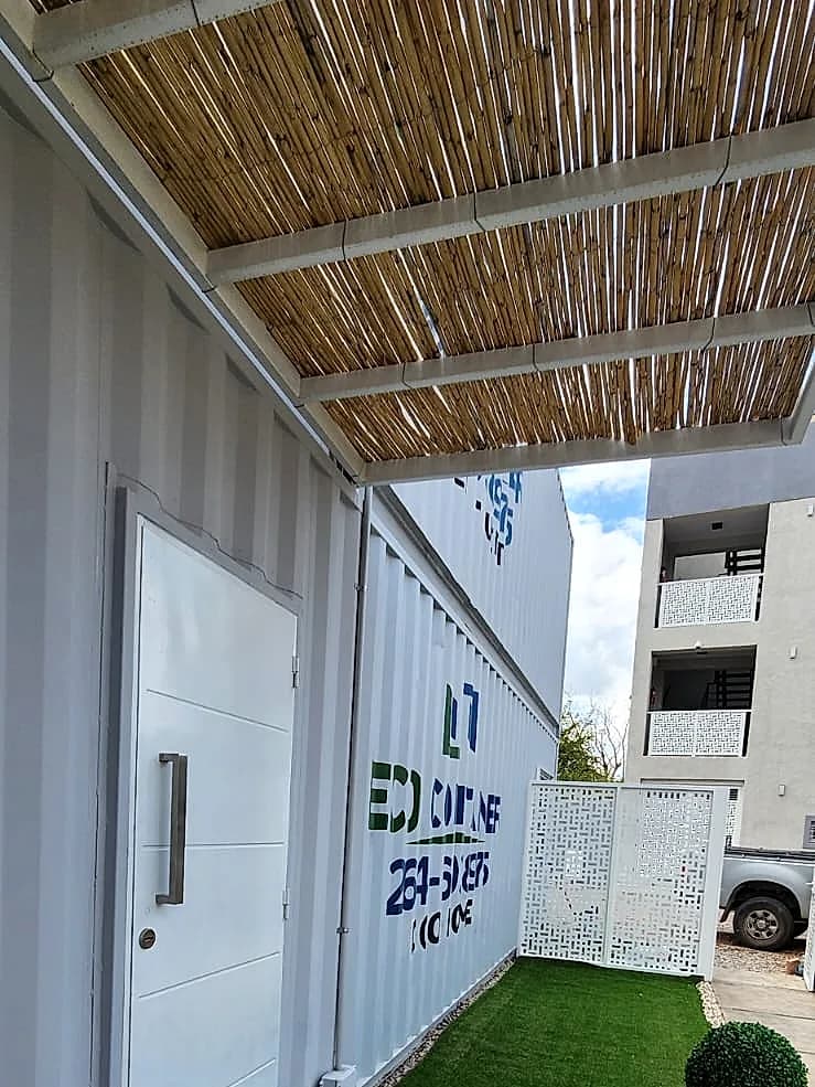 Acceso exterior con puerta de seguridad, galería de cañas y jardín lateral