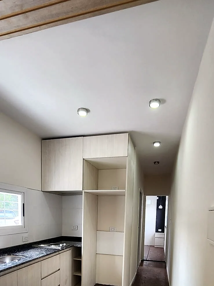 Vista longitudinal de la cocina equipada y la circulación hacia los ambientes privados