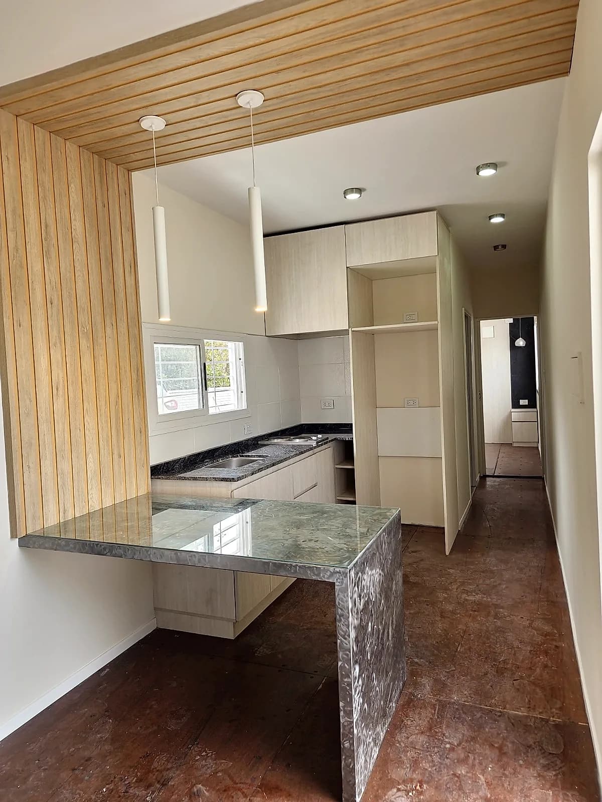 Interior del Eco Home con barra, cocina equipada y cielorraso de madera