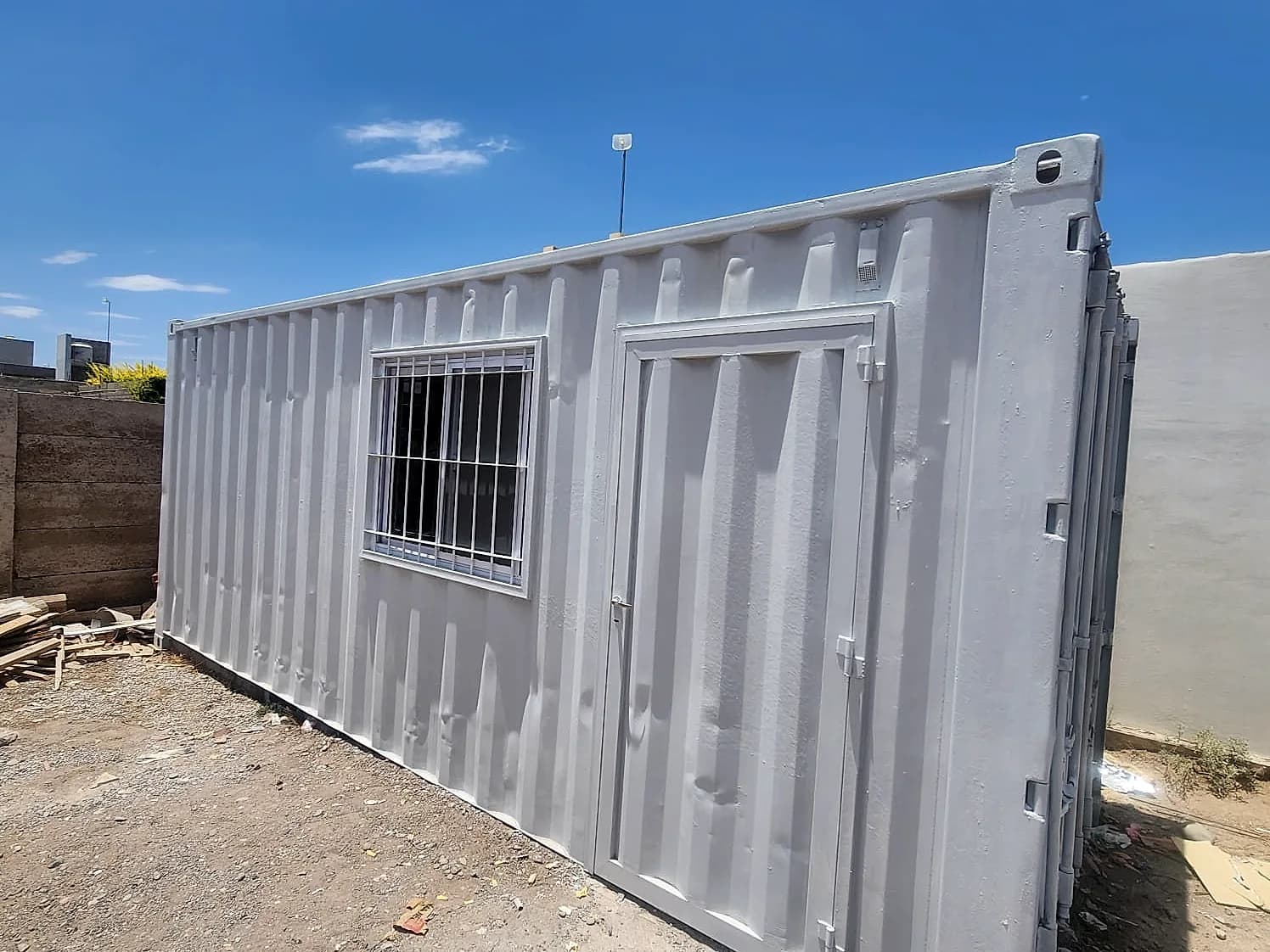 Container Eco Office terminado con puerta, ventana enrejada e iluminación exterior