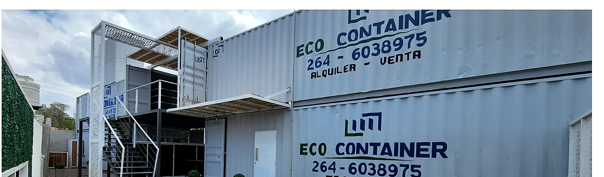 Instalaciones de Eco Container en San Juan: containers apilados en dos niveles con escalera metálica, pérgola y jardín